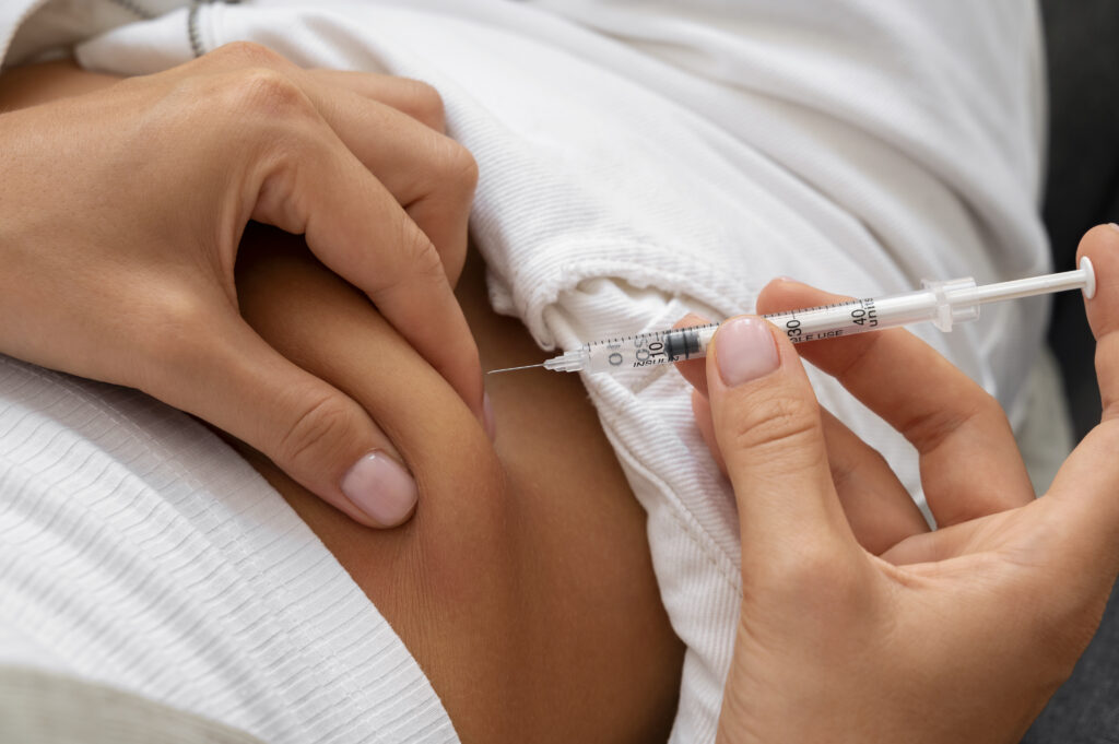 high angle woman injecting insulin home